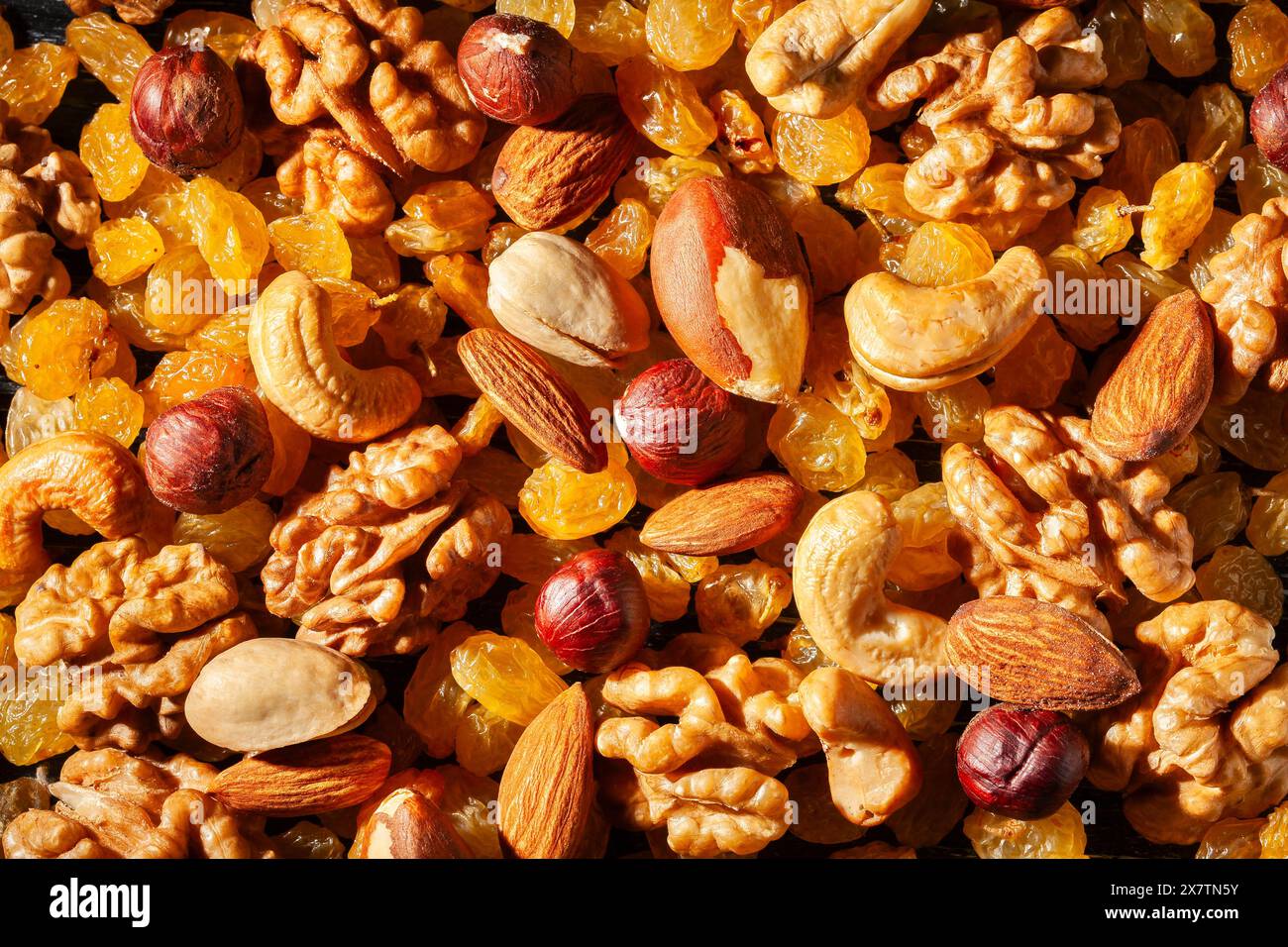 Nüsse Rosinen auf schwarzem Holz Hintergrund von oben Stockfoto