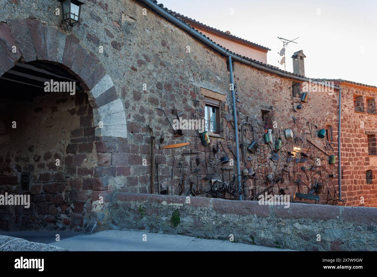 10.05.2024, Prades, Spanien: Eingangsbogen zur Stadt Prades mit landwirtschaftlichen Werkzeugen an der Fassade Stockfoto