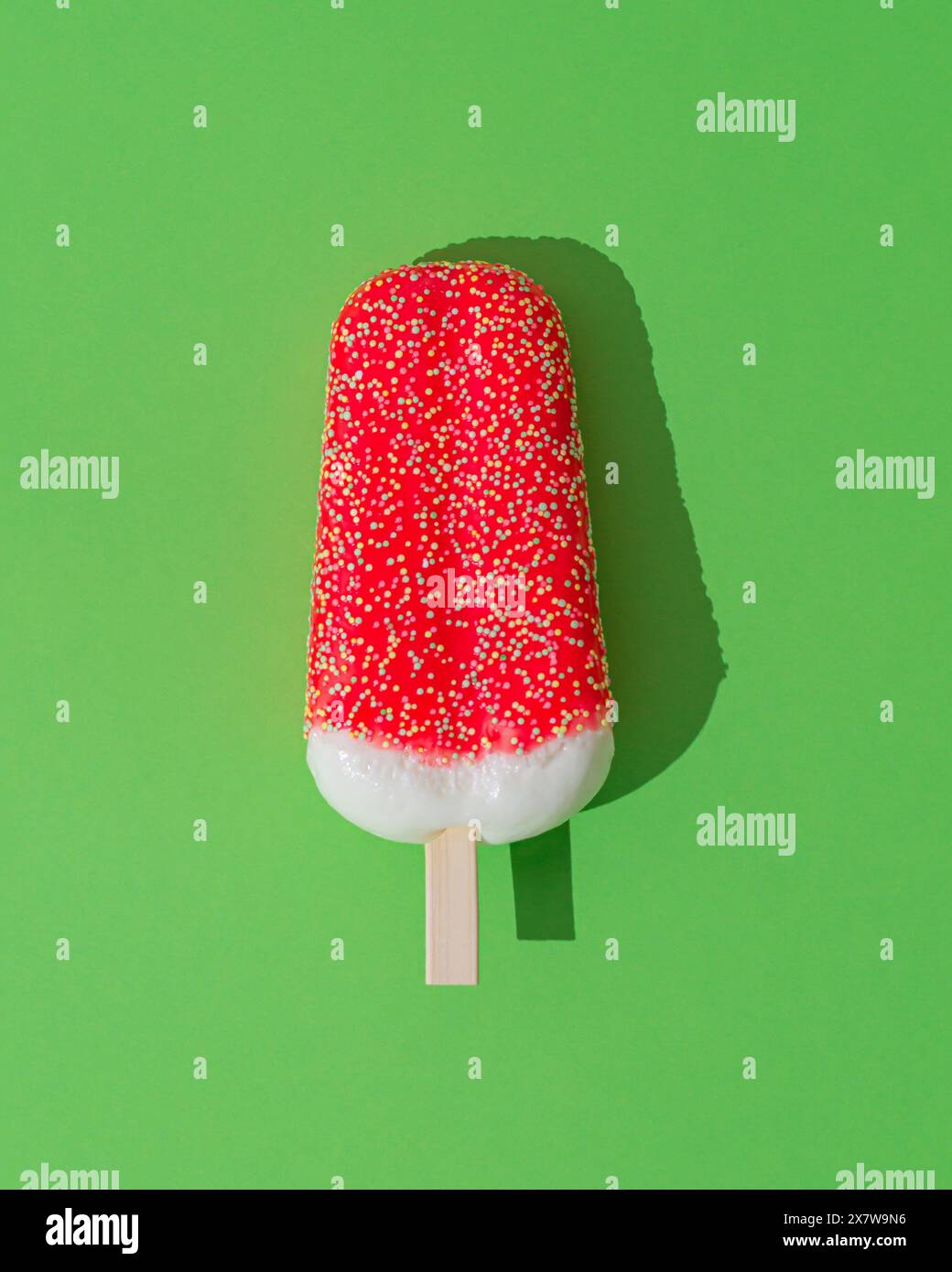 Rot glasiertes Eis-Eis-Eis auf hellgrünem Hintergrund. Minimales Sommerkonzept. Eisästhetik. Flache Lagen. Stockfoto