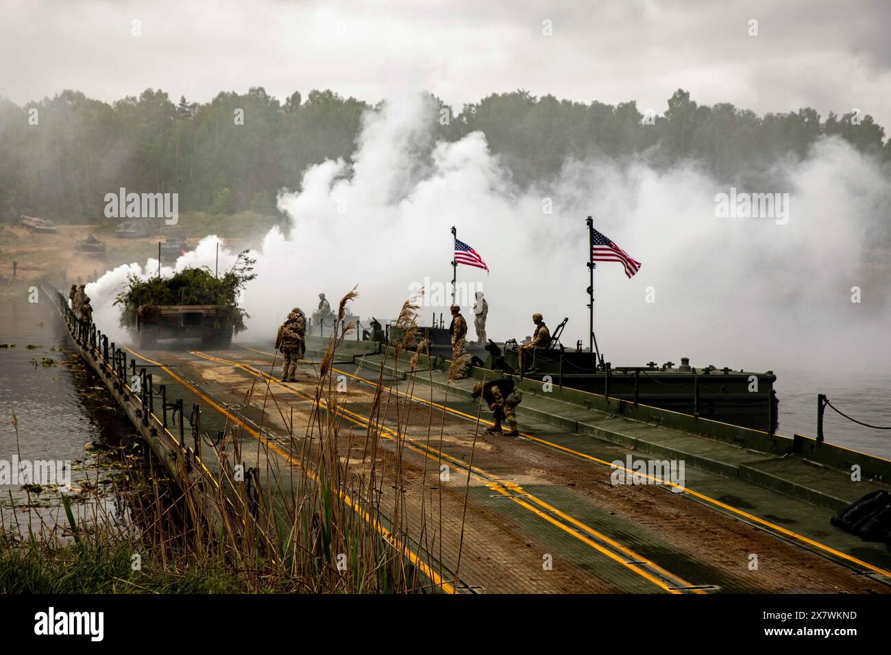 11. Mai 2024 – Polen – Soldaten der 43. Mehrrollen-Brückenkompanie, 20. Ingenieurbataillon, 36. Ingenieurbrigade, führen eine Wet Gap Crossing Übung im Drawsko Combat Training Center, Polen, durch, um die Sofortreaktion zu unterstützen 24, 11. Mai 2024. Eine Wet Gap Crossing ist eine taktische Operation, bei der verbesserte Ribbon Bridges über ein Wasserhindernis, wie einen Fluss oder einen See, eingesetzt werden. Dieses Manöver ermöglicht den Transport von Ausrüstung und Truppen über eine Vielzahl von nassen Geländebedingungen, wodurch entscheidende Zeit in Kriegsszenarien eingespart werden kann. Rauch kann zur zusätzlichen Abdeckung abgeleitet werden. DEFENDER ist ein Dynami Stockfoto 11. Mai 2024 – Polen – Soldaten der 43. Mehrrollen-Brückenkompanie, 20. Ingenieurbataillon, 36. Ingenieurbrigade, führen eine Wet Gap Crossing Übung im Drawsko Combat Training Center, Polen, durch, um die Sofortreaktion zu unterstützen 24, 11. Mai 2024. Eine Wet Gap Crossing ist eine taktische Operation, bei der verbesserte Ribbon Bridges über ein Wasserhindernis, wie einen Fluss oder einen See, eingesetzt werden. Dieses Manöver ermöglicht den Transport von Ausrüstung und Truppen über eine Vielzahl von nassen Geländebedingungen, wodurch entscheidende Zeit in Kriegsszenarien eingespart werden kann. Rauch kann zur zusätzlichen Abdeckung abgeleitet werden. DEFENDER ist ein Dynami Stockfoto