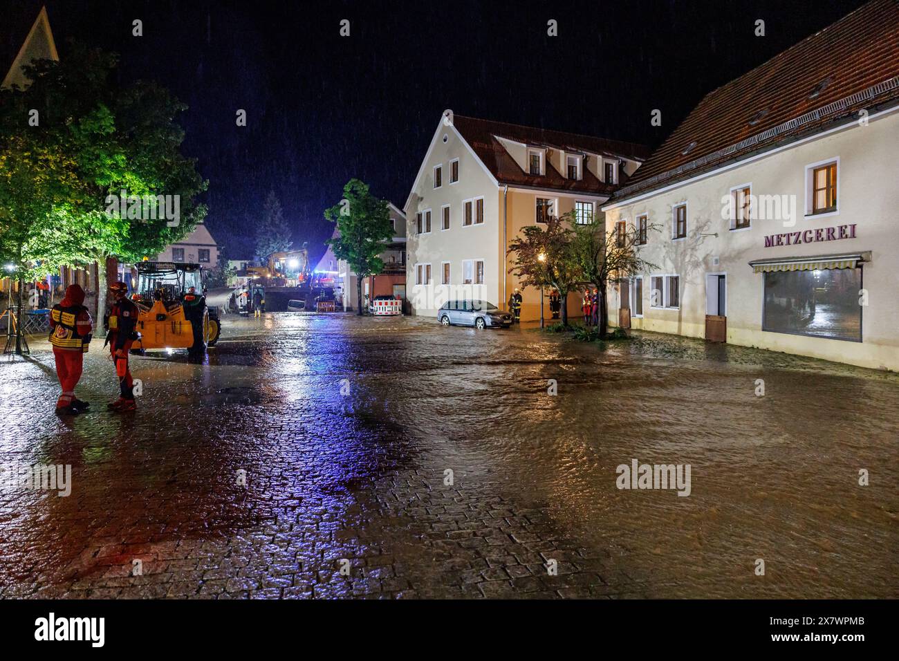 Kastl, Deutschland. Mai 2024. Feuerwehrleute arbeiten in den Überschwemmungen. Nach starkem Regen aus der Lauterach fließen Massen über den Marktplatz in der Gemeinde Kastl. Autos flogen über die Straßen, Menschen waren in ihren Häusern gefangen. Vermerk: Daniel Karmann/dpa/Alamy Live News Stockfoto