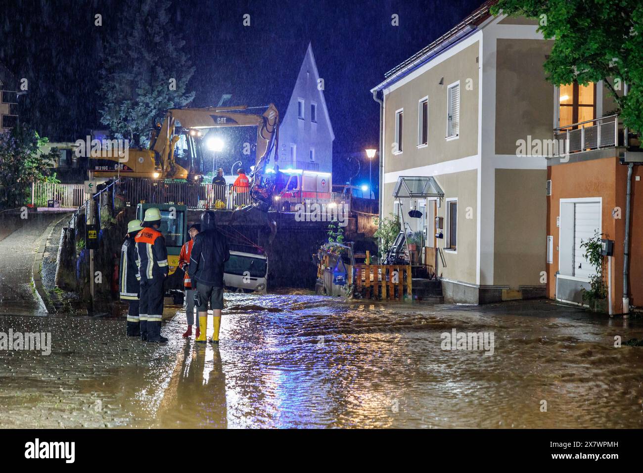 Kastl, Deutschland. Mai 2024. Feuerwehrleute arbeiten in den Überschwemmungen. Nach starkem Regen aus der Lauterach fließen Massen über den Marktplatz in der Gemeinde Kastl. Autos flogen über die Straßen, Menschen waren in ihren Häusern gefangen. Vermerk: Daniel Karmann/dpa/Alamy Live News Stockfoto