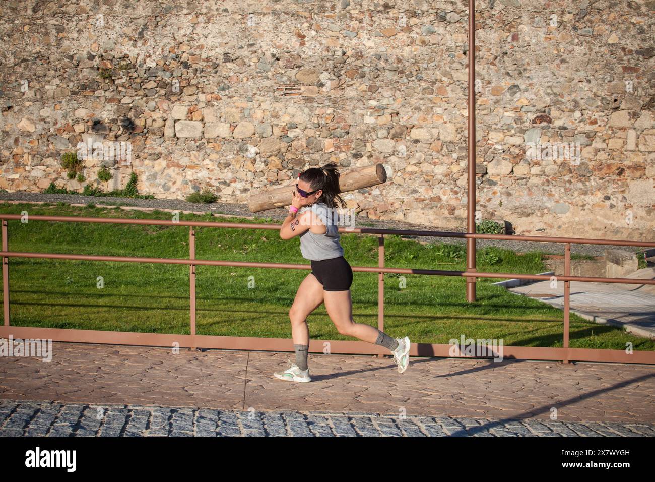 Merida, Spanien - 18. Mai 2024: FarinatoRace Merida 2024. Eine Frau, die einen schweren Baumstamm auf der Schulter trägt Stockfoto