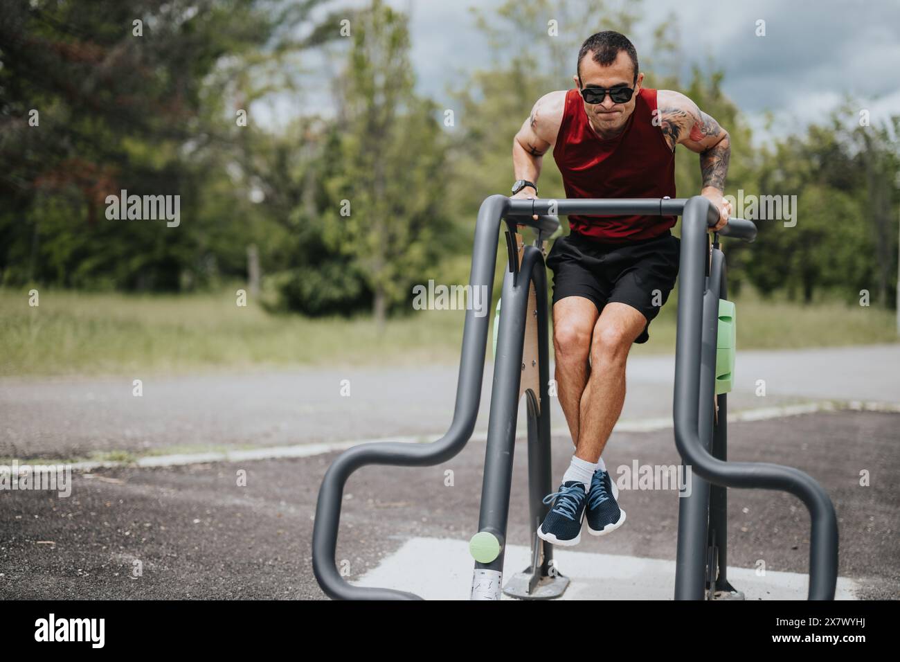 Fitness-Enthusiasten, die in einem üppigen urbanen Park in den Bars im Freien tauchen Stockfoto