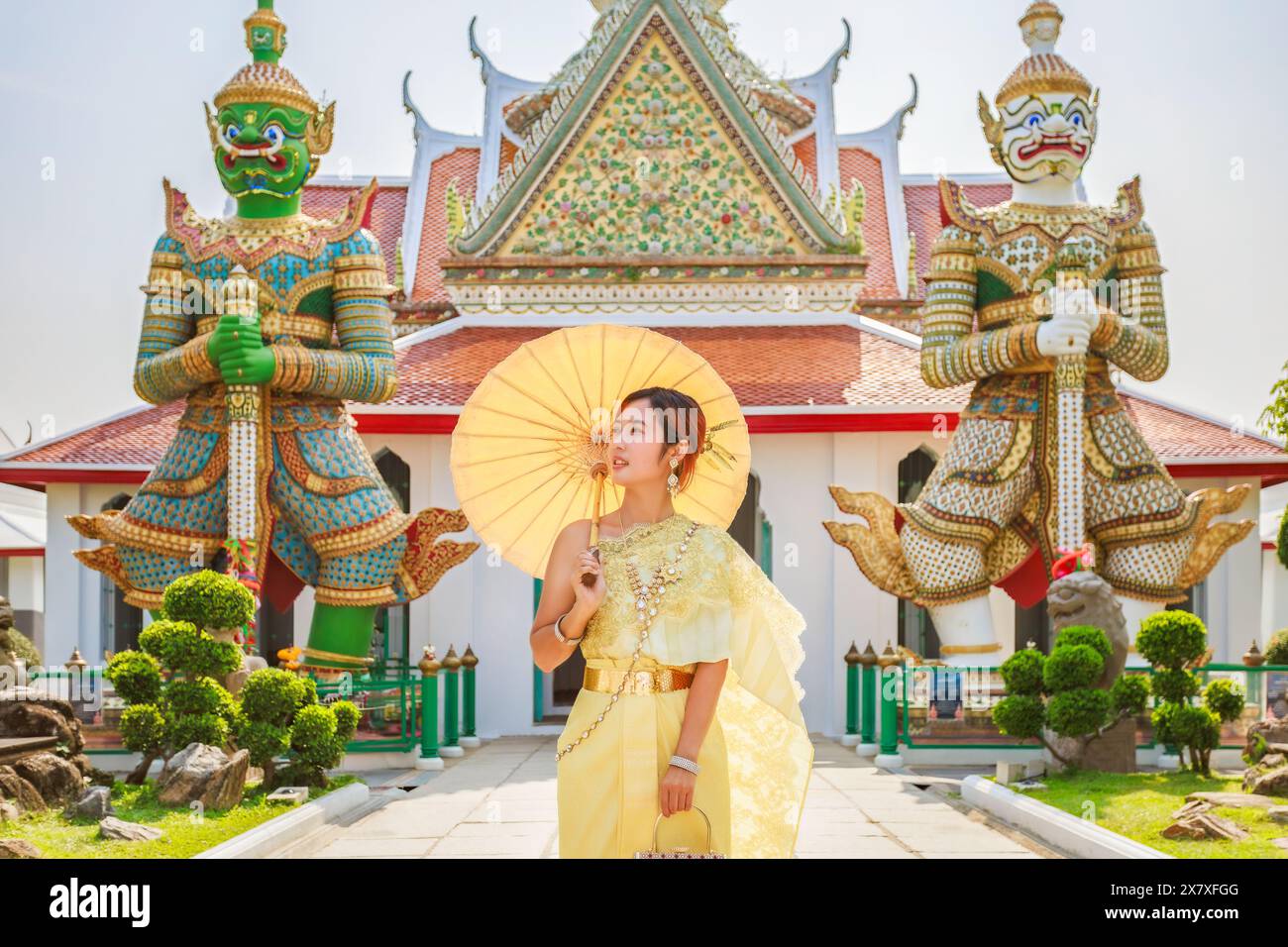 Touristen in traditioneller thailändischer Kleidung machen Fotos im Wat Arun Ratchawararam Woramahawihan in Bangkok, Thailand Stockfoto