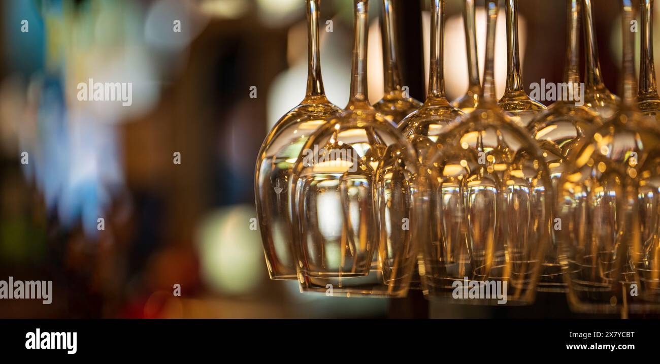 Weingläser, die im warmen Ambiente hängen, schaffen eine elegante Bar- oder Restaurantatmosphäre. Stockfoto
