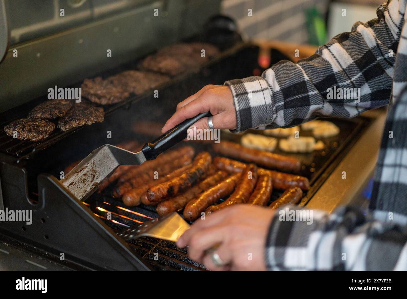Person, die Fleisch auf dem Grill zuhause im Hinterhof kocht Stockfoto