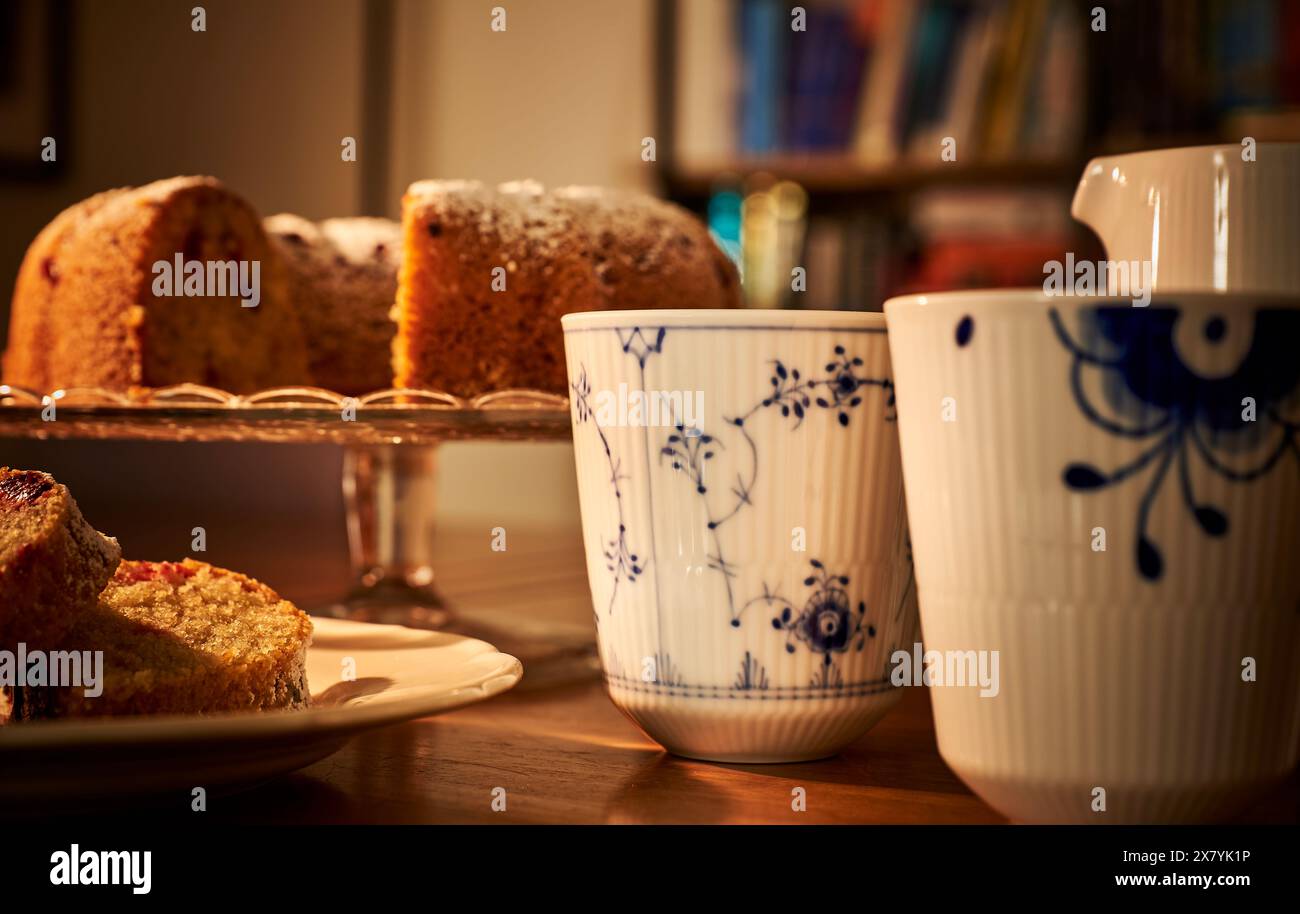 Luxuriöse, altmodische Tasse warmen Kaffee mit einer Scheibe GF Donut in einer romantischen Umgebung. Gemütliches Ambiente mit aufgeschnittenem Donut und einer luxuriösen Tasse Tee Stockfoto