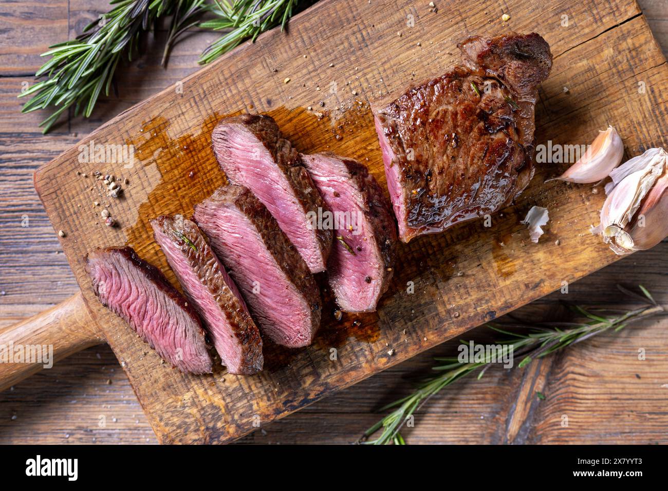 Frisch gegrilltes, geschnittenes Steak auf hölzernem Schneidebrett, Blick von oben Stockfoto