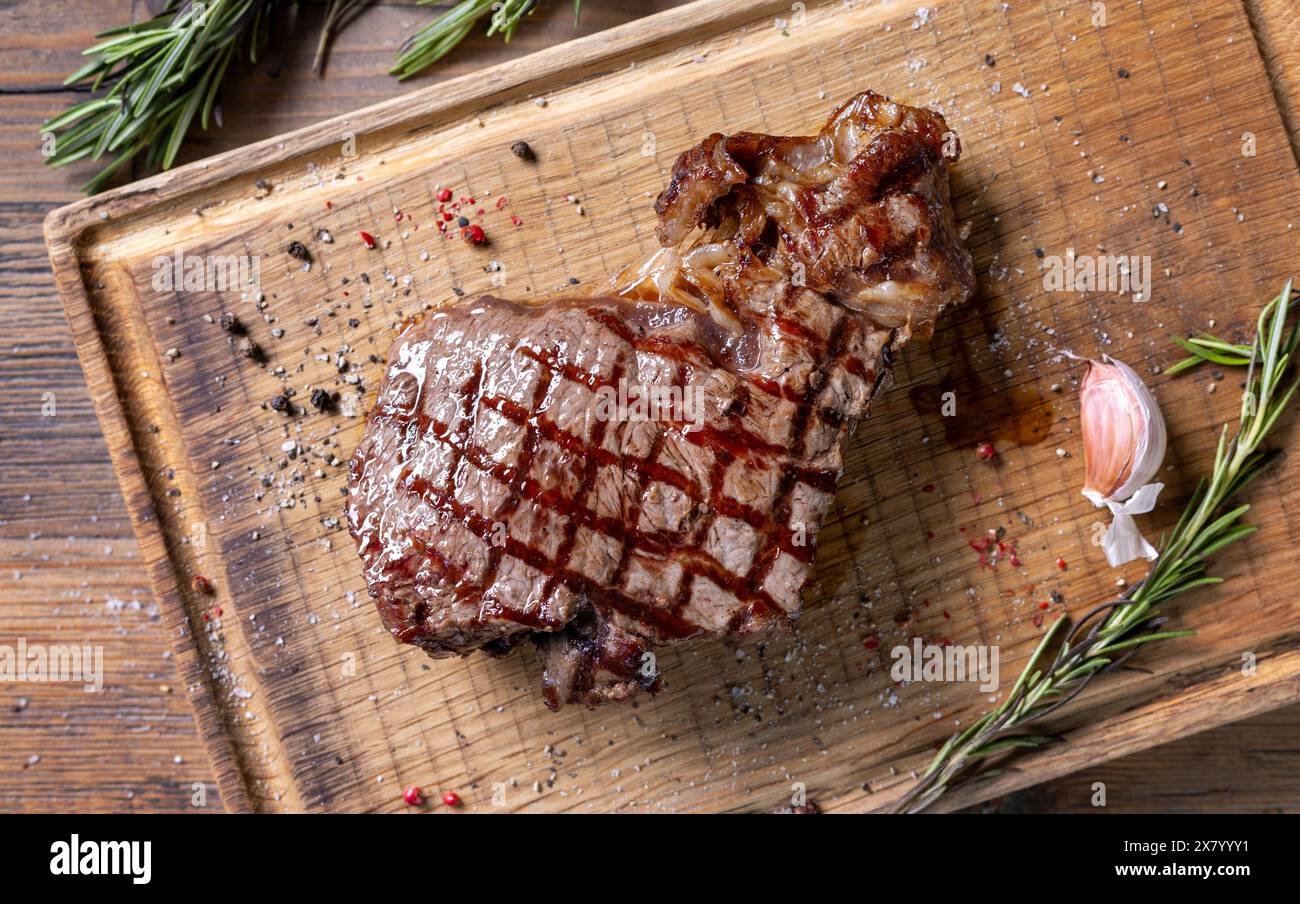 Frisch gegrilltes Steak auf hölzernem Schneidebrett, Blick von oben Stockfoto