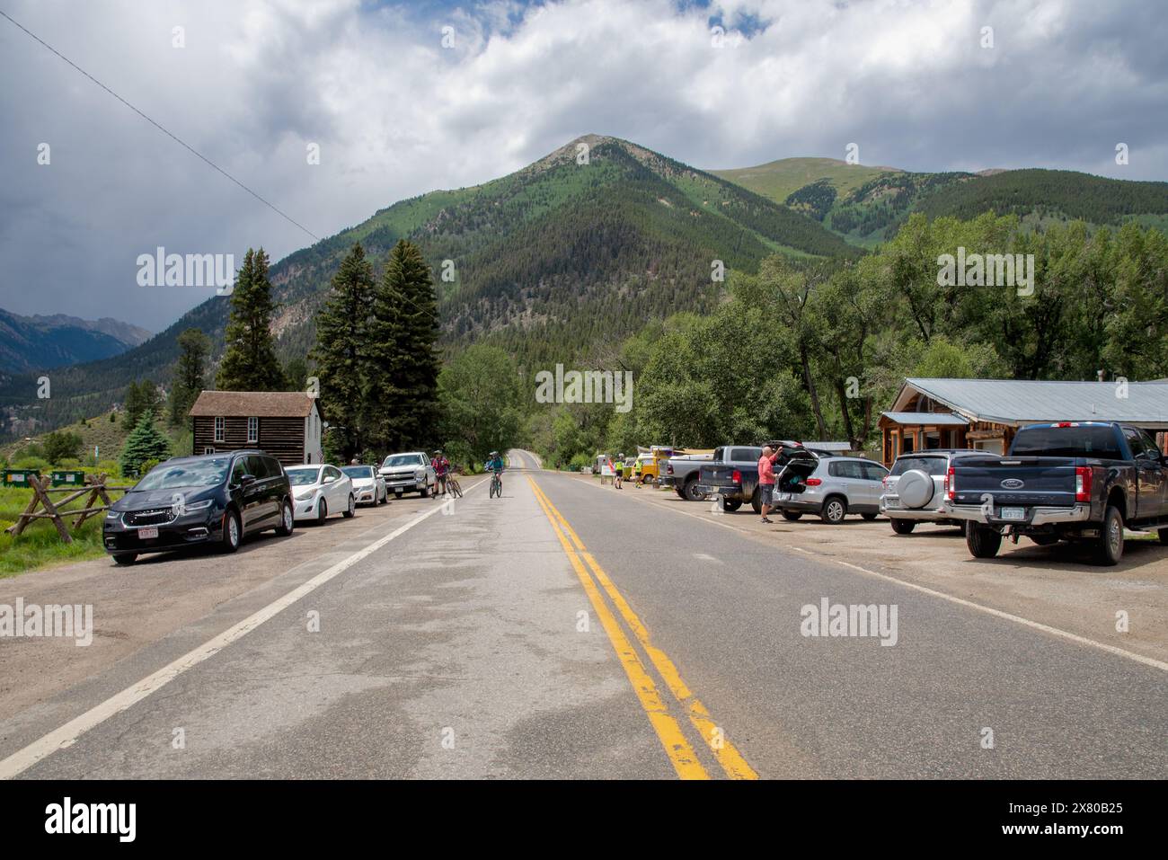 Autos und Lastwagen parken am Highway 82, Radfahrer auf der Straße, in Twin Lakes, Colorado, dem östlichen Tor zum Independence Pass, USA. Stockfoto