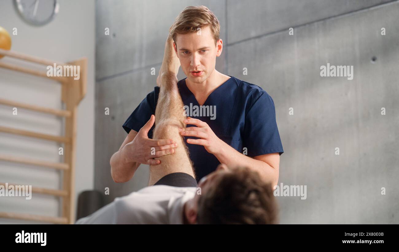 Nahaufnahme eines jungen männlichen Athleten, der sich Physiotherapie unterzieht, professioneller Sportmasseur, der leichte Muskel- oder Gelenkverletzungen behandelt. Muskuloskelettale Schmerztherapie und Rehabilitationskonzept. Stockfoto