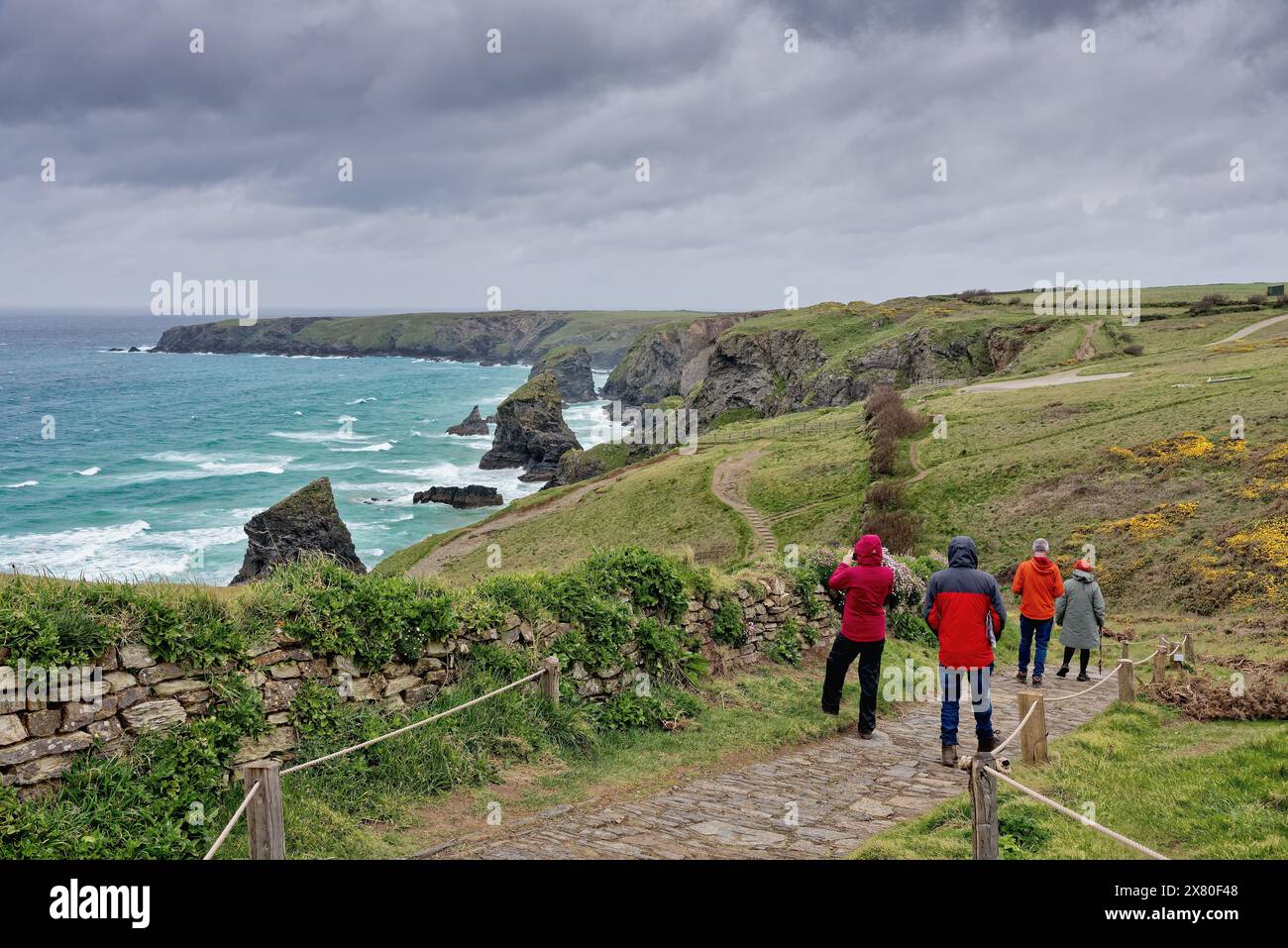 Ramblers genießen den spektakulären Blick auf die Küste von Bedruthan Steps North Cornwall an einem stürmischen Frühlingstag England Großbritannien Stockfoto