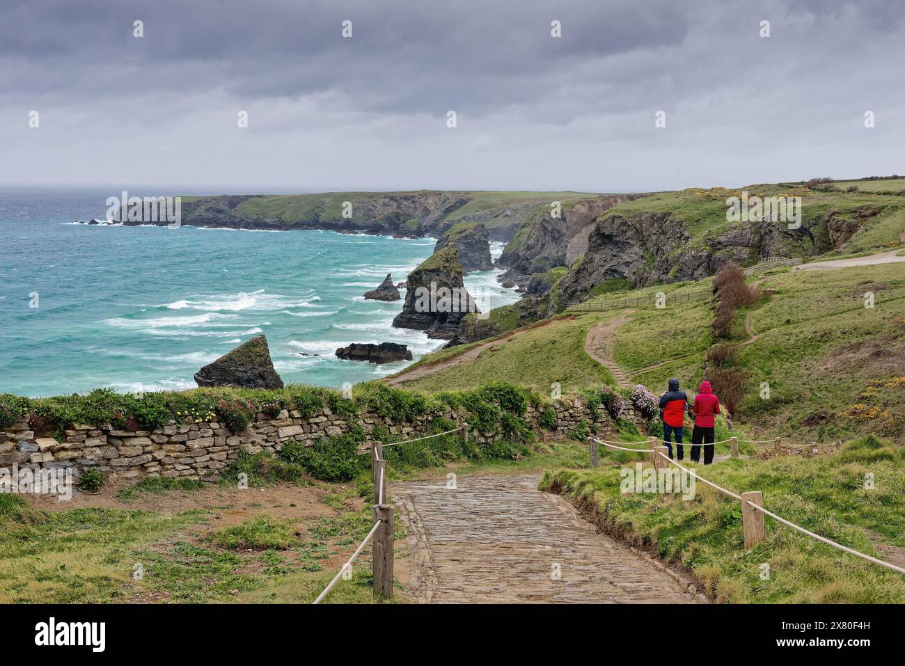 Ramblers genießen den spektakulären Blick auf die Küste von Bedruthan Steps North Cornwall an einem stürmischen Frühlingstag England Großbritannien Stockfoto