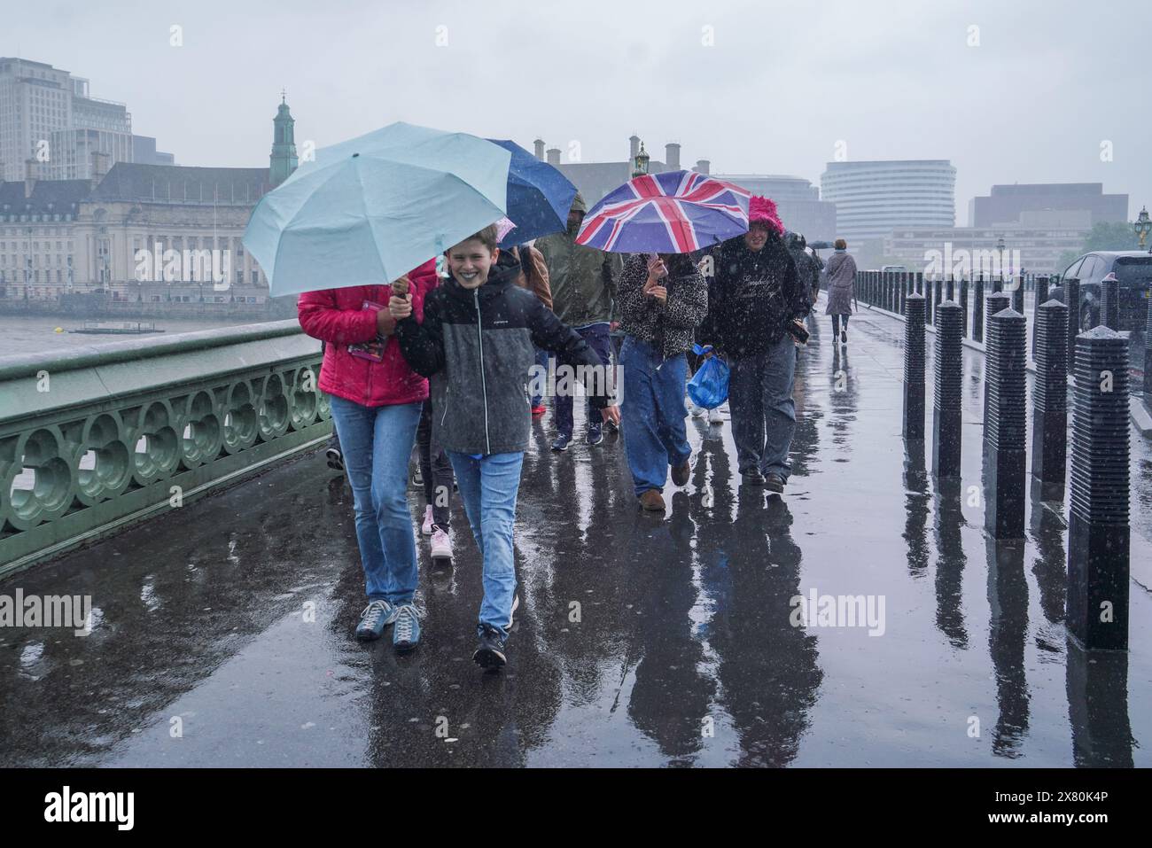 Westminster, London, Großbritannien. Mai 2024. Fußgänger trotzen dem Regen, wenn sie die Westminster Bridge überqueren. Eine Wetterwarnung wurde für Überschwemmungen und Gewitter in London und Südengland veröffentlicht Credit: amer ghazzal/Alamy Live News Stockfoto