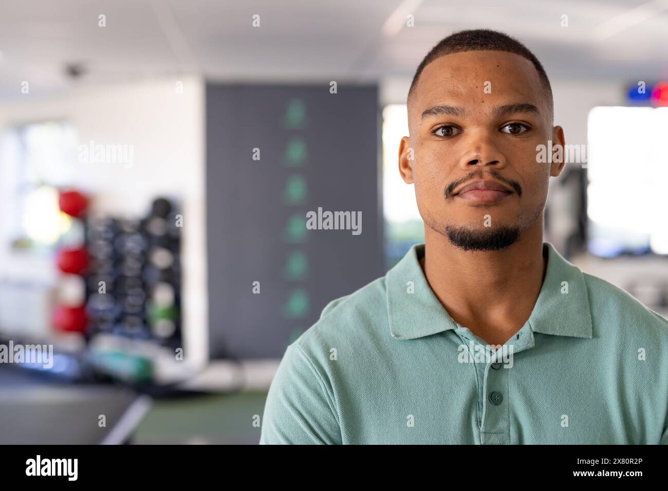 Im Reha-Center steht ein junger männlicher Physiotherapeut in einem grünen Poloshirt Stockfoto