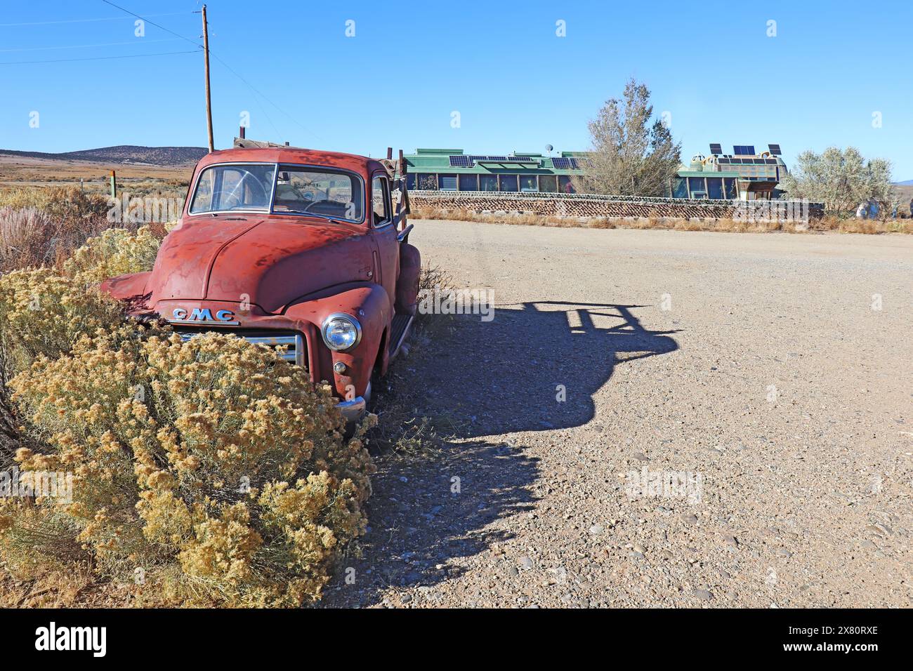 Altes Auto- und Erdschiffgebäude mit Gewächshaus und Solarpaneelen, Teil der Greater World Earthship Community, in der Nähe von Taos, New Mexico Stockfoto