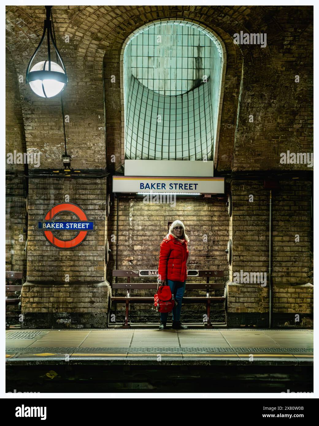 Farbbild einer Einzelperson, die auf dem U-Bahnsteig 6 der Baker Street gegenüber der Position der Kamera auf dem anderen Bahnsteig steht Stockfoto