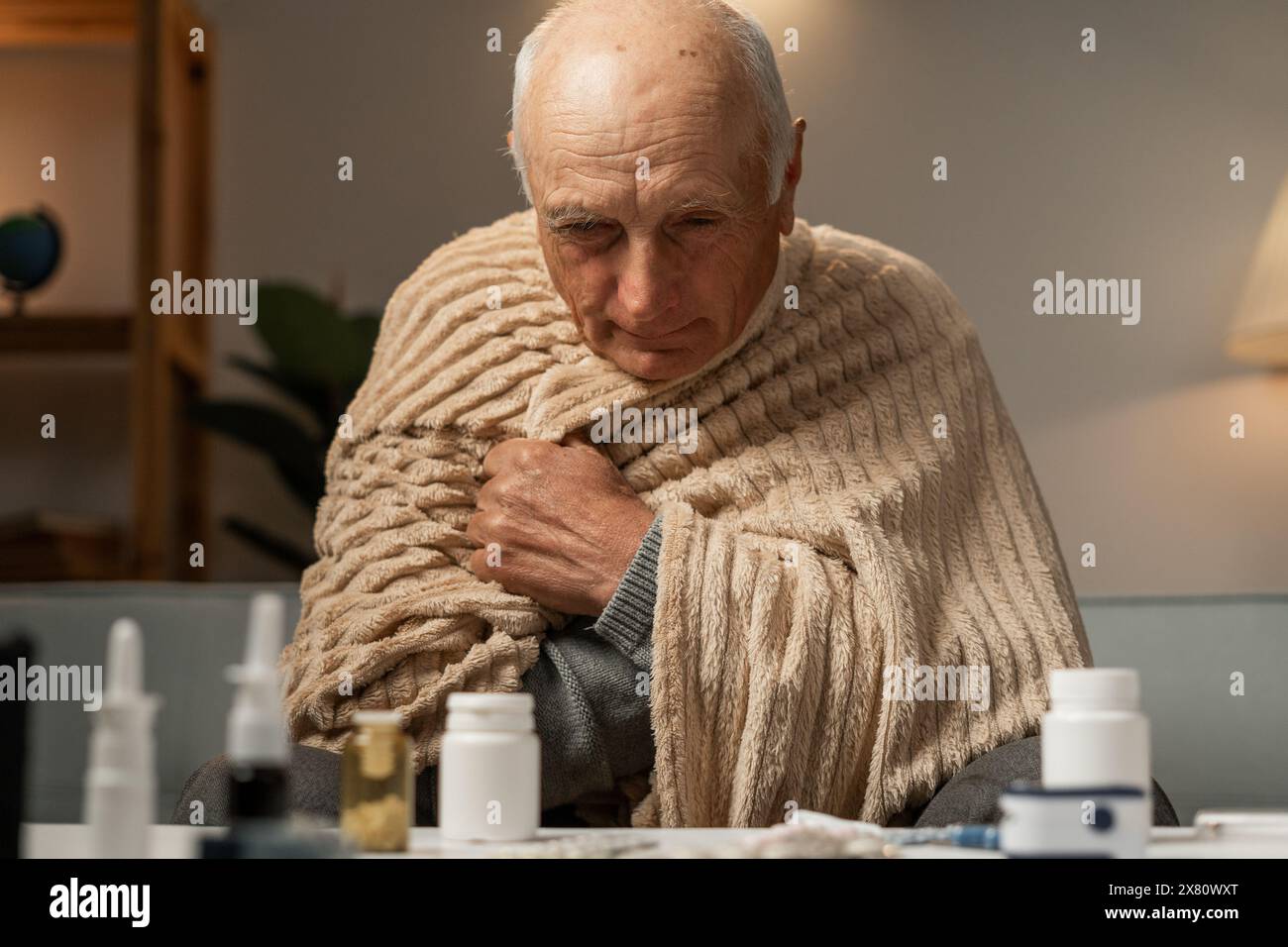 Nahaufnahme eines älteren Kranken in Decke. Temperatur, Kälte. Einnahme von Grippemedikamenten Stockfoto