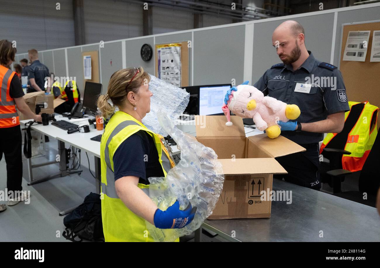 Schkeuditz, Deutschland. Mai 2024. Zollbeamter Florian Näther inspiziert am DHL Hub ein Kuscheltier aus China, das nicht den europäischen Sicherheitsstandards entspricht. Die Sicherheit importierter Produkte ist ein Kriterium, das der Zoll unter anderem den Luftfrachtknoten genauer betrachtet. Um diese Sicherheit zu gewährleisten, wird eine Kombination aus Kennzeichnung und wirksamen Kontrollen verwendet. Quelle: Hendrik Schmidt/dpa/Alamy Live News Stockfoto