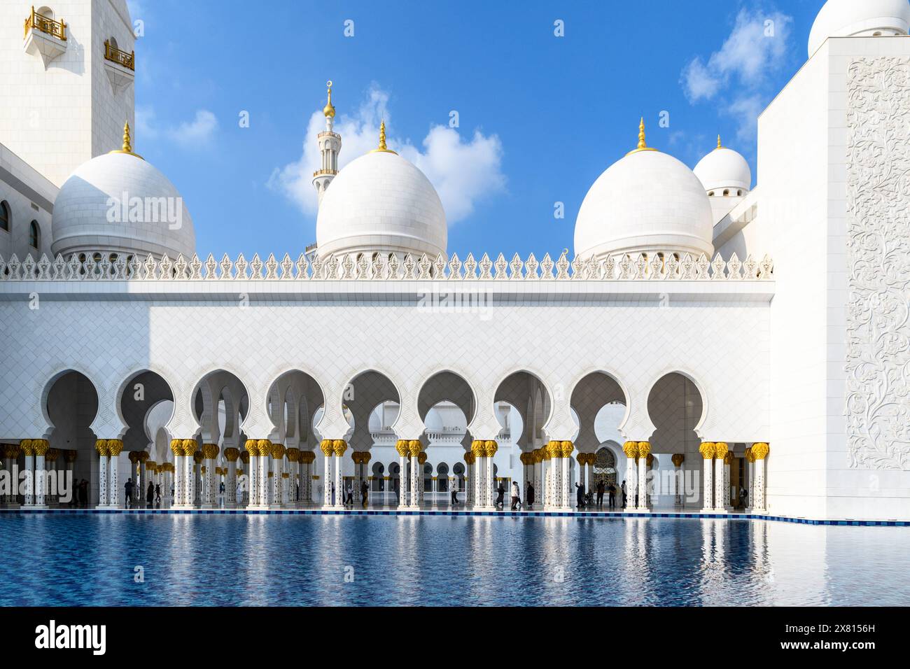 Ein bezaubernder Blick bei Tageslicht auf die Scheich-Zayed-Moschee in Abu Dhabi, VAE, enthüllt ihre architektonische Pracht unter dem hellblauen Himmel. Stockfoto