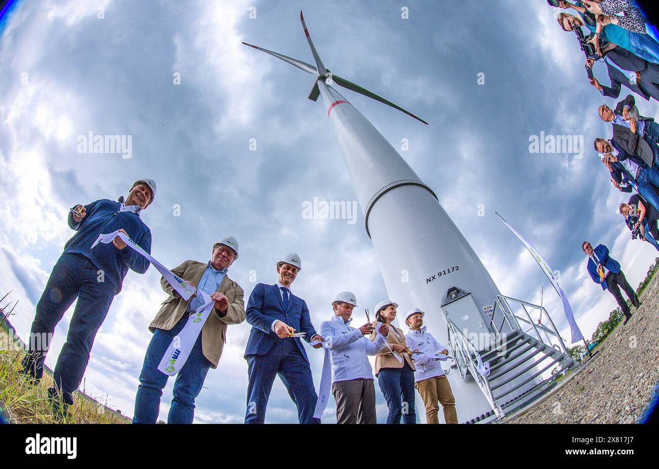 22. Mai 2024, Mecklenburg-Vorpommern, Rieps: Torsten Hinrich (l-r), Geschäftsführer von MEA, Dirk Fröhling, Bürgermeister von Rieps, Roland Ilper, Geschäftsführer des Energieverbunds Nord, Casper Baumgart, CEO des Energieunternehmens WEMAG, Ines Jesse, Staatssekretär im Wirtschaftsministerium von Mecklenburg-Vorpommern, und Stefan Sternberg, Landrat von Ludwigslust-Parchim und Aufsichtsratsmitglied des Energieverbunds Nord, schneidet bei der offiziellen Eröffnung des neuen Windparks Rieps das Band (Foto mit Ultraweitwinkelobjektiv). Das Pilotprojekt von Mecklenburg-Vorpom Stockfoto