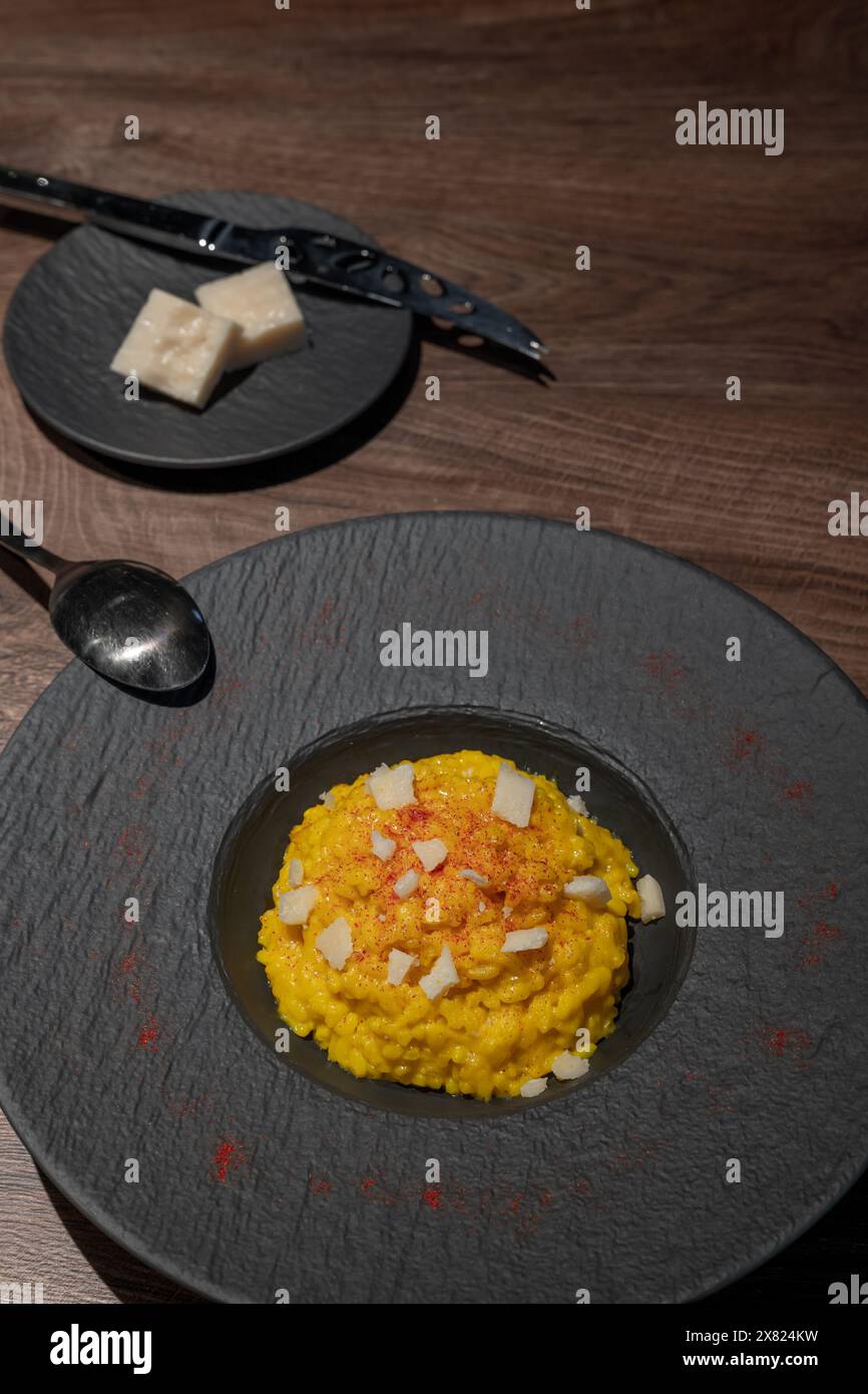 Eleganter Teller mit Risotto alla Milanese mit Safran und Parmesan in Lugano, Tessin, Schweiz. Stockfoto