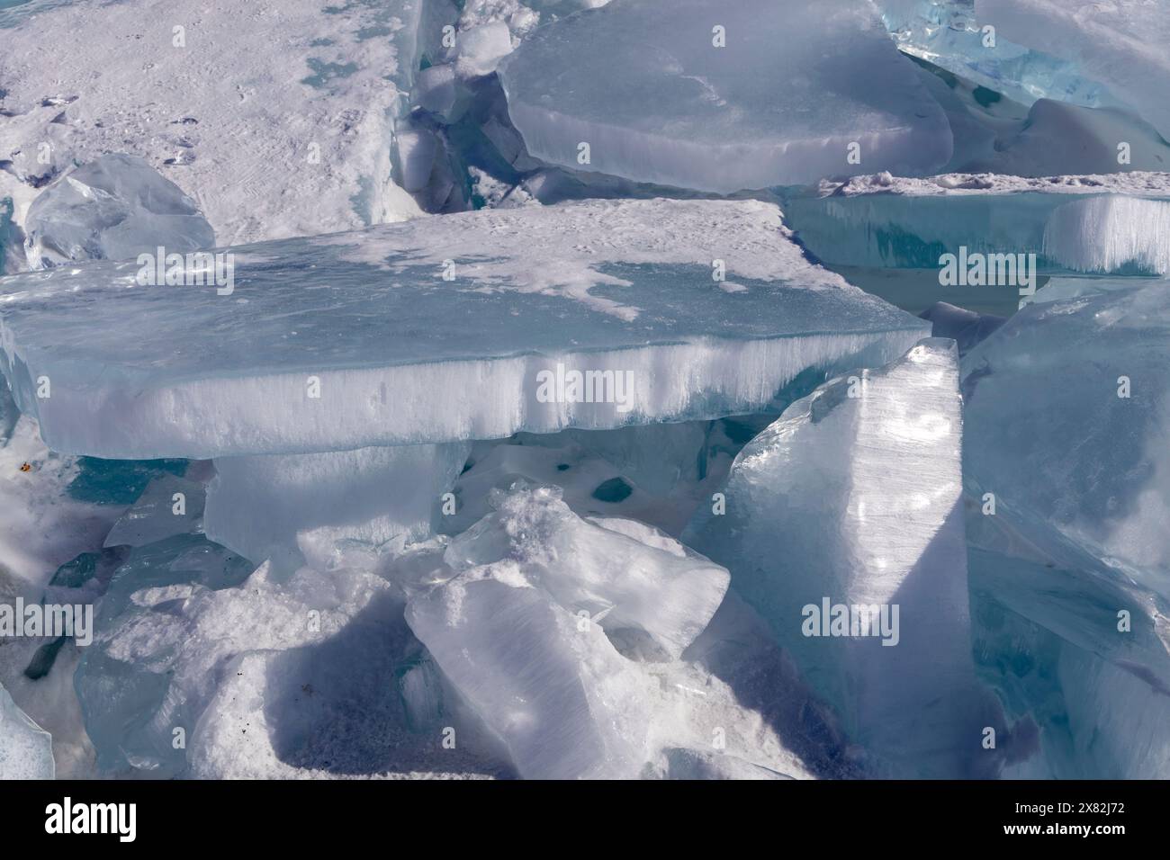 Der natürliche Winterhintergrund mit Bruchstücken von blauem Eis und Haufen von Eisschollen am Baikalsee an einem sonnigen frostigen Tag. Abstrakter kalter Hintergrund, Stockfoto