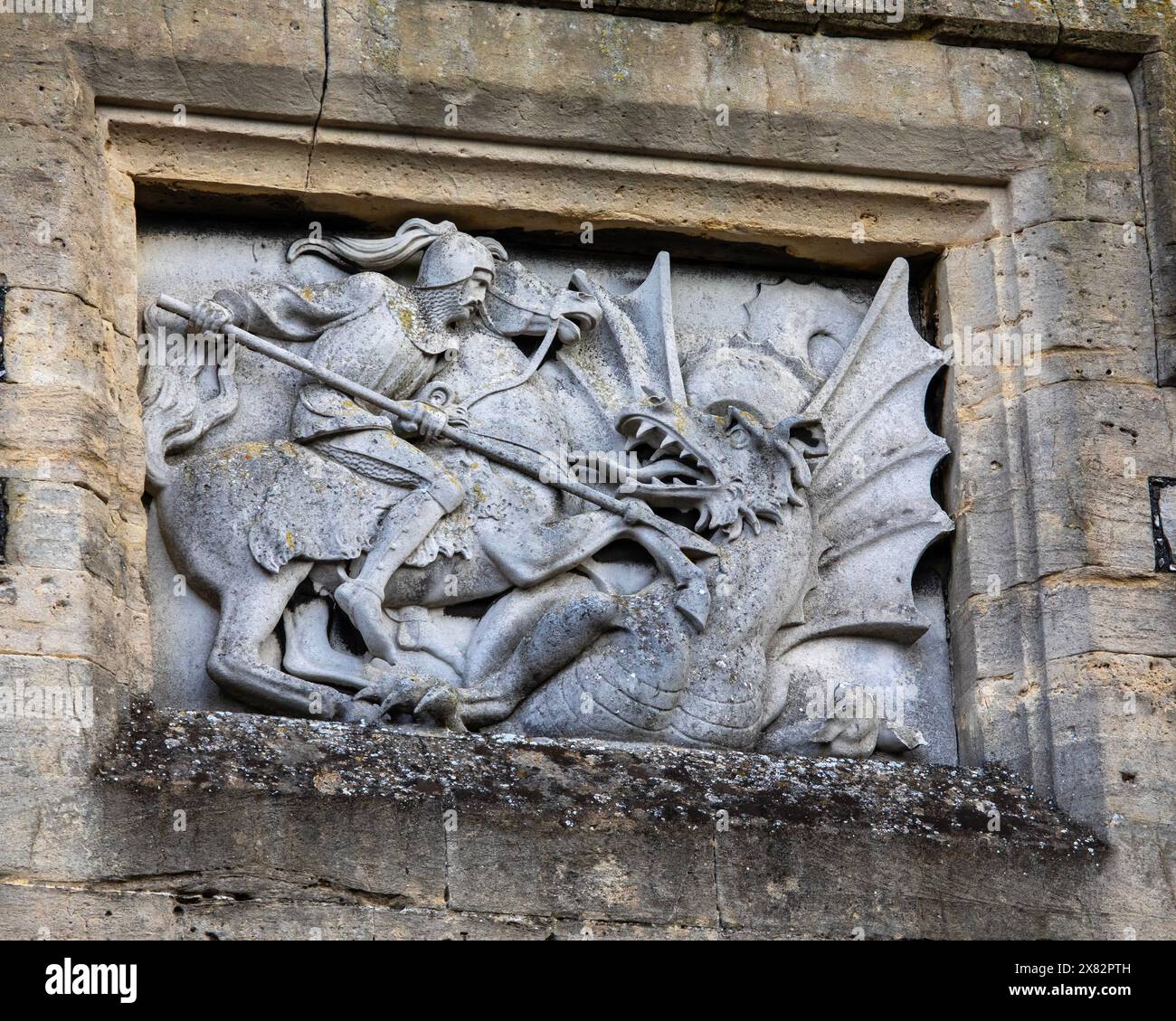 Windsor, Großbritannien - 21. Oktober 2023: Nahaufnahme einer Steinskulptur, die den Heiligen Georg bei der Niederlage eines Drachen darstellt, auf dem prächtigen Windsor Castle in BER Stockfoto