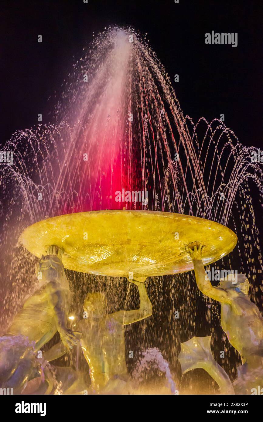 Abstrakter gelber Brunnen in Bewegung mit spritzendem Wasser in der Nacht Stockfoto