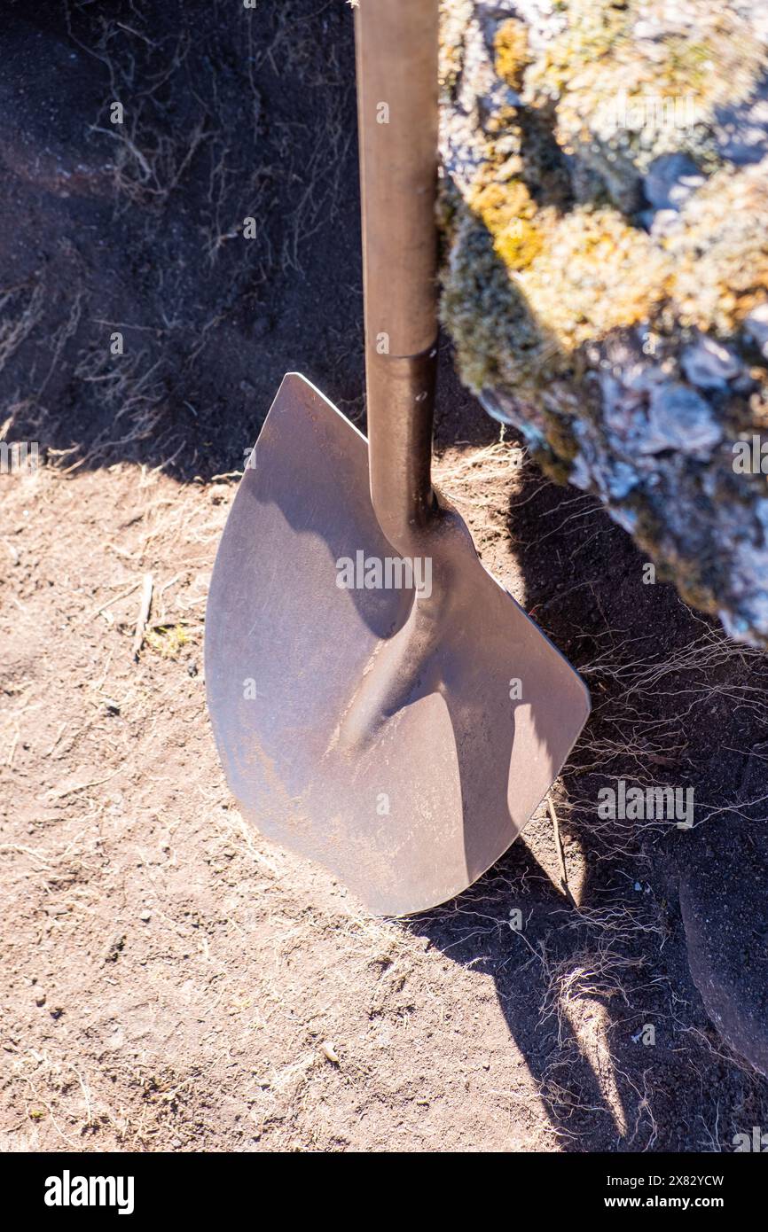 Eine Schaufel auf einem Felsen bei einer archäologischen Ausgrabung Stockfoto