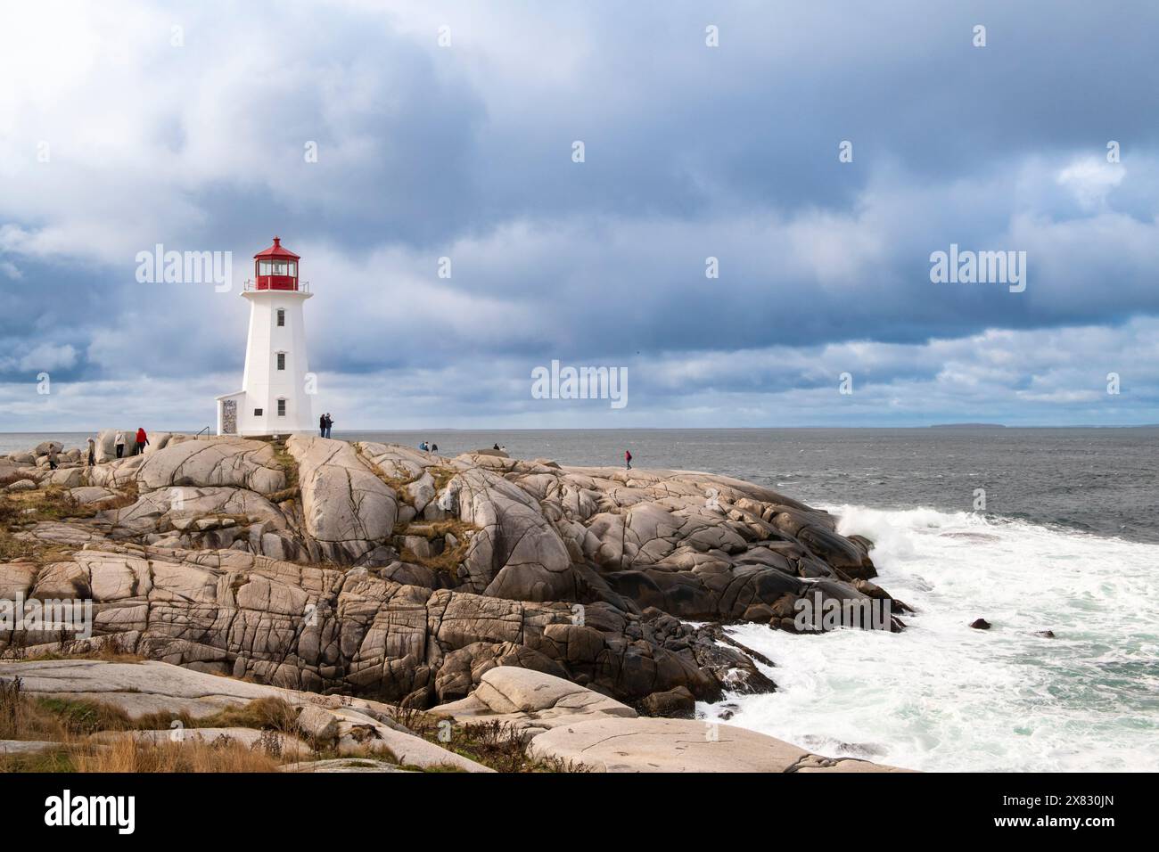 Peggy's Cove, Nova Scotia, Kanada - 23. Oktober 2023: Blick auf den Leuchtturm von Peggy's Cove, mit Besuchern entlang der Felsen, in Nova Scotia, Kanada. Stockfoto