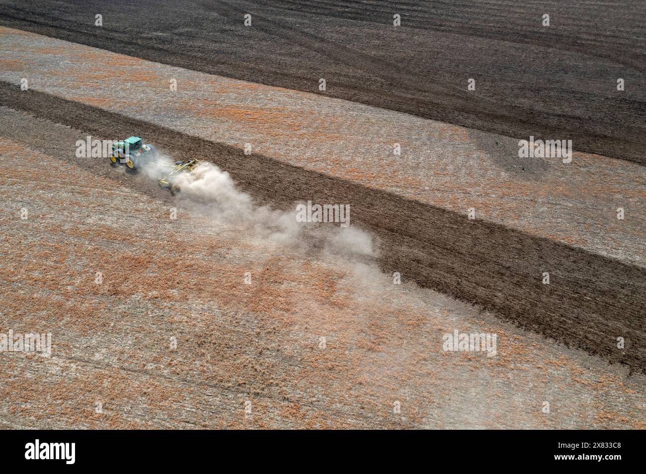 Hudson, Michigan – Eine Staubwolke bläst hinter den Traktor, während ein Landwirt sein Feld bebaut. Stockfoto