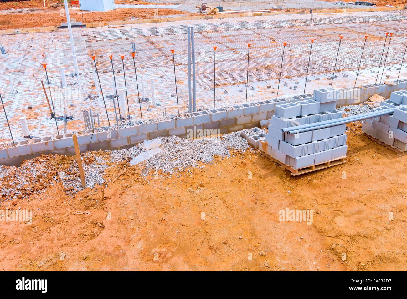 Ab sofort kann Beton auf den oberen Bewehrungsmetallrahmen gegossen werden, um das Fundament zu bilden. Stockfoto