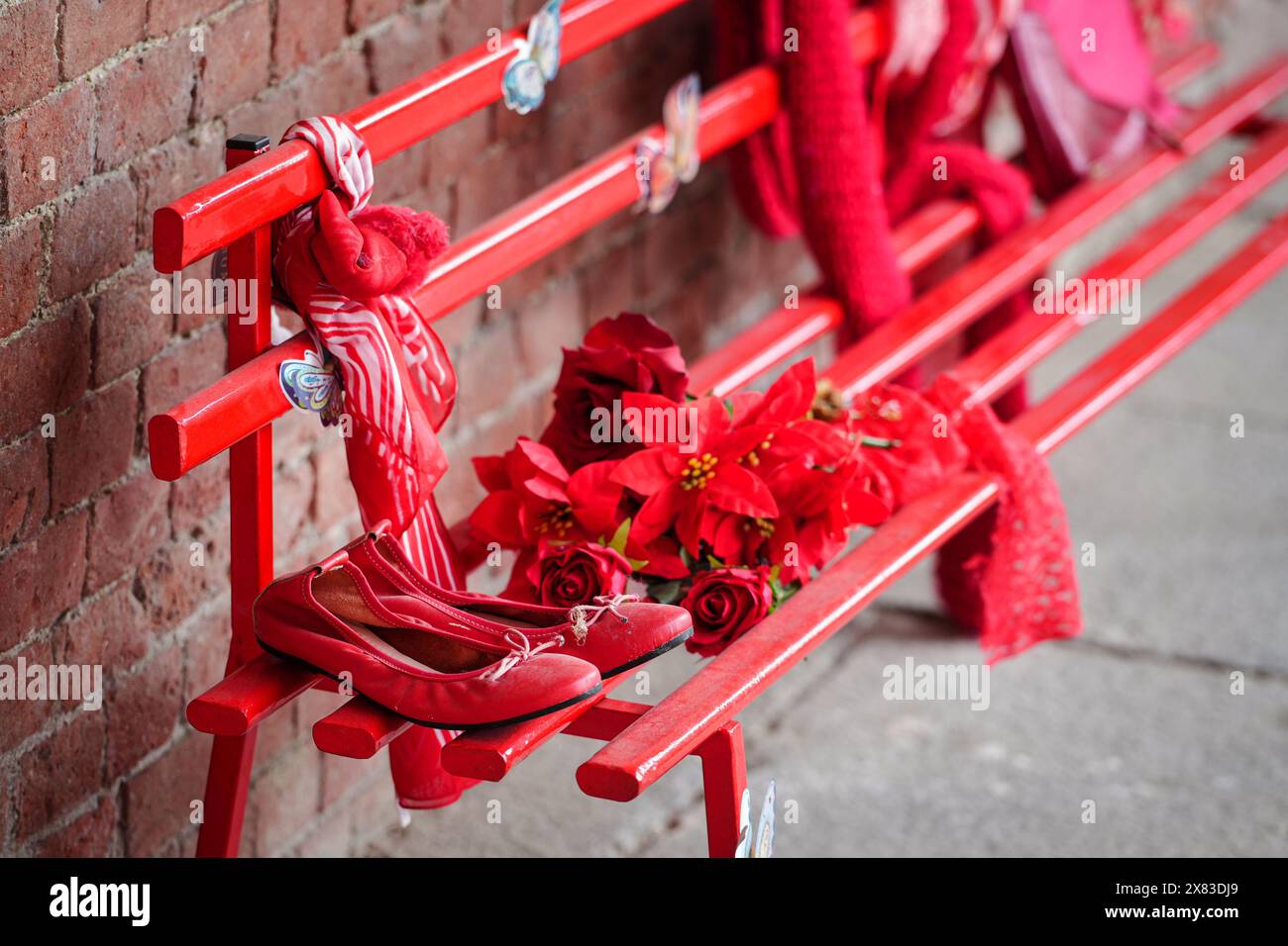 Rote Schuhe auf der Bank gegen Gewalt gegen Frauen Stockfoto
