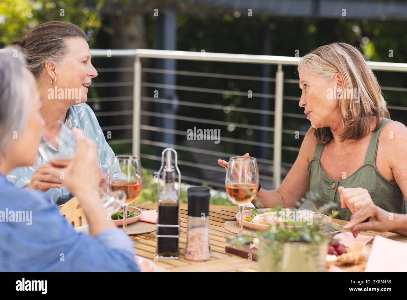 Verschiedene ältere Freundinnen, die im Freien essen Stockfoto