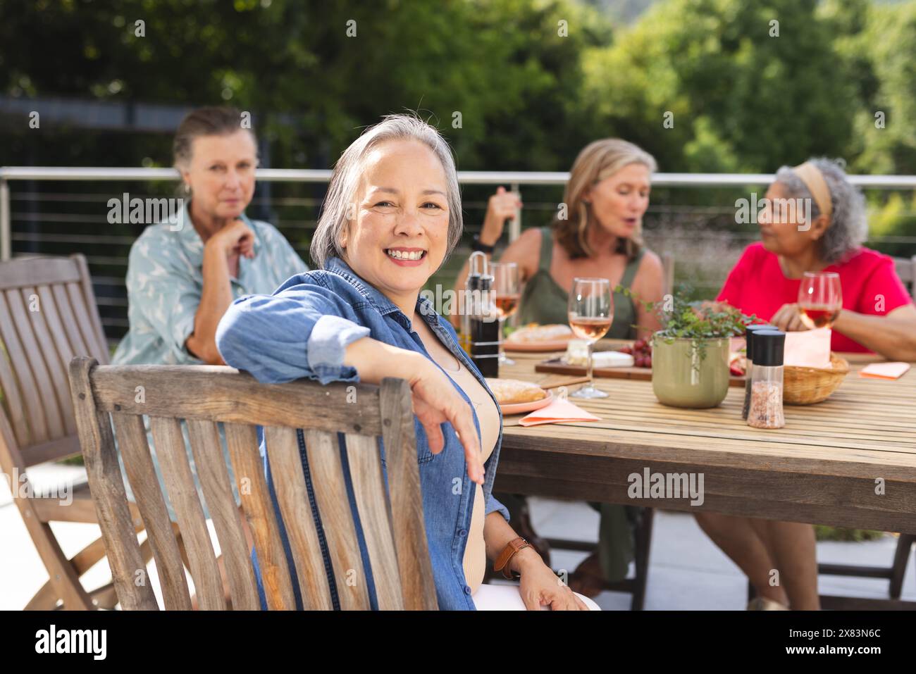 Verschiedene ältere Freundinnen, die im Freien essen und Geschichten erzählen Stockfoto