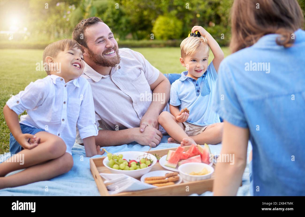 Mom, Dad und Kinder picknicken im Park, um am Wochenende zu knüpfen, zu essen und die Familie auf Gras zusammen zu glücklich zu machen. Mutter, Vater und Kinder im Garten mit gesunden Stockfoto