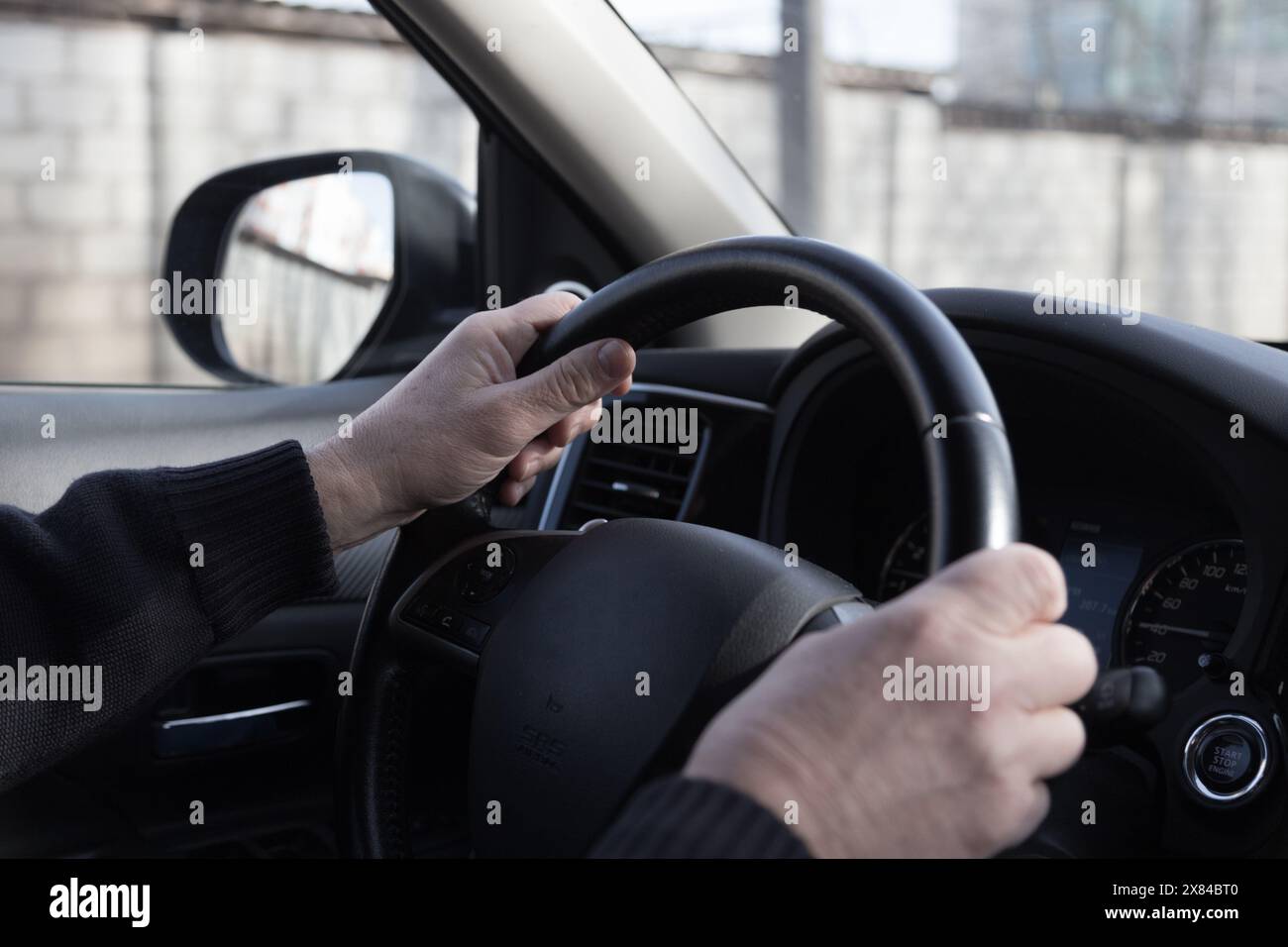 Die Hände des Fahrers sind am Lenkrad. Blick von der Innenseite des Autos. Nahaufnahme. Stockfoto Die Hände des Fahrers sind am Lenkrad. Blick von der Innenseite des Autos. Nahaufnahme. Stockfoto