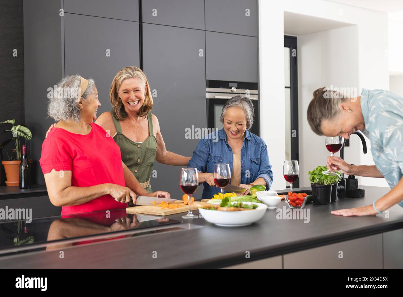 Verschiedene ältere Freundinnen lachen, zubereiten zu Hause Essen Stockfoto