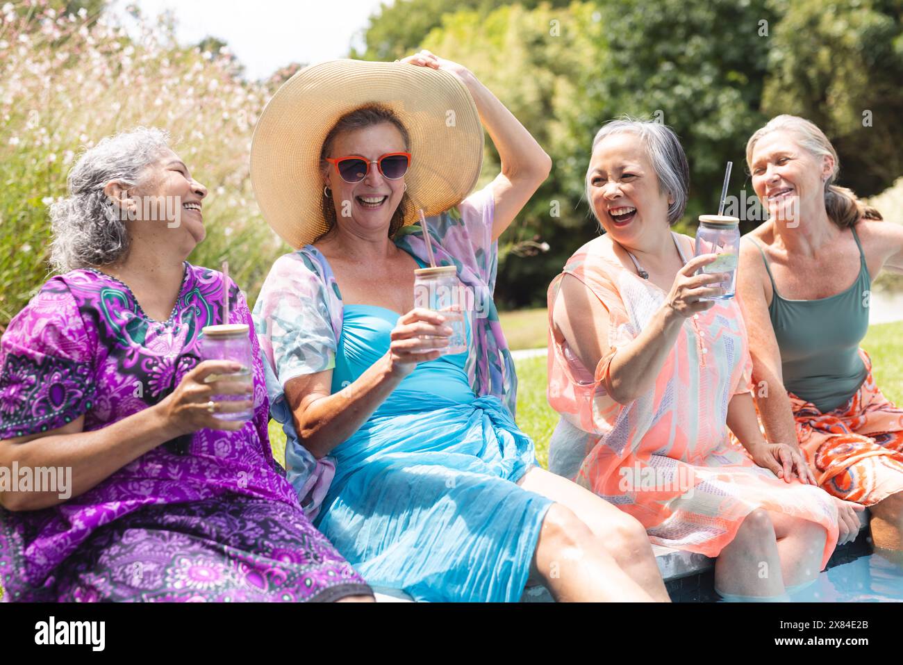 Im Freien lachen verschiedene ältere Freundinnen am Pool Stockfoto