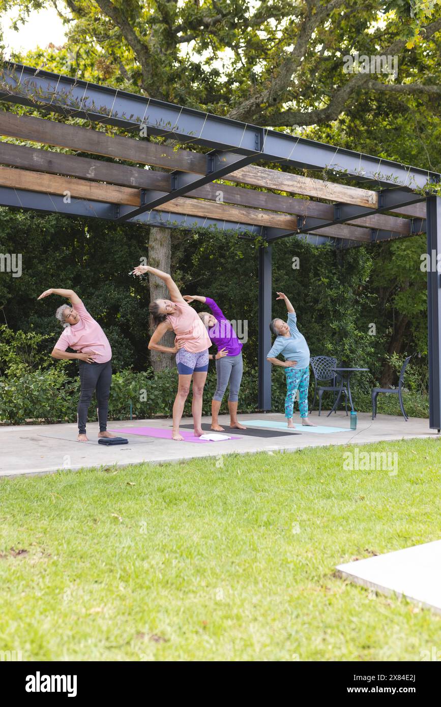 Im Freien, verschiedene ältere Freundinnen dehnen und Yoga machen Stockfoto