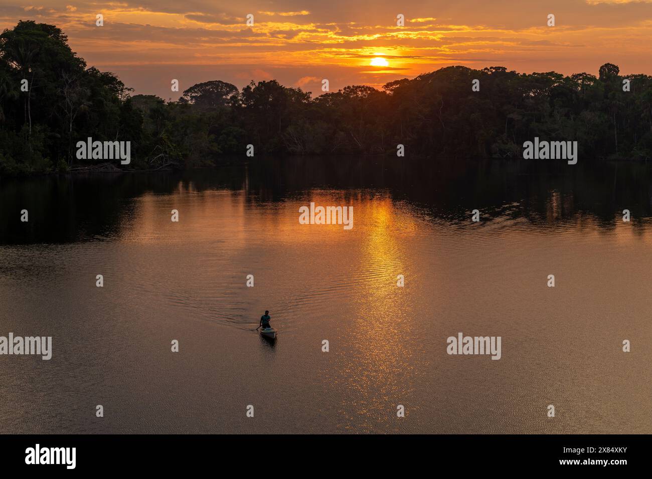 Sonnenaufgang im Amazonas-Regenwald mit Einheimischen im Kanu, Yasuni-Nationalpark, Ecuador. Stockfoto