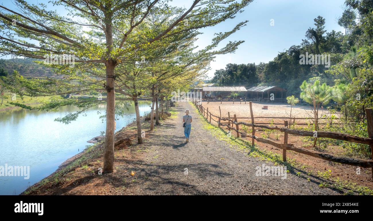 Eine Frau läuft auf einer Landstraße in Gia Nghia, Provinz Dak Nong, Vietnam. Stockfoto