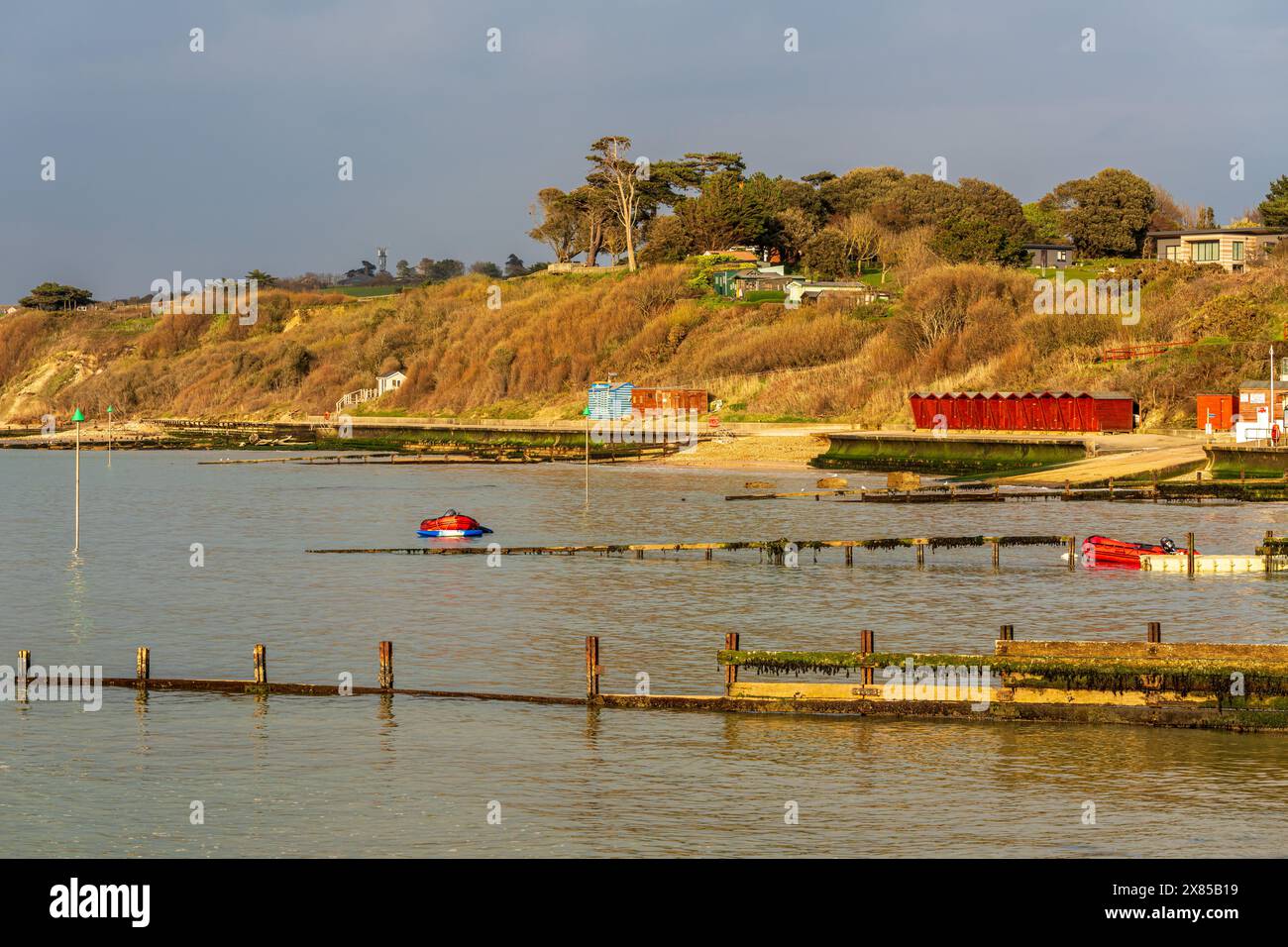 Colwell Bay, Isle of Wight, England, Großbritannien - 17. April 2023: Blick auf die Strandhütten und die Promenade Stockfoto