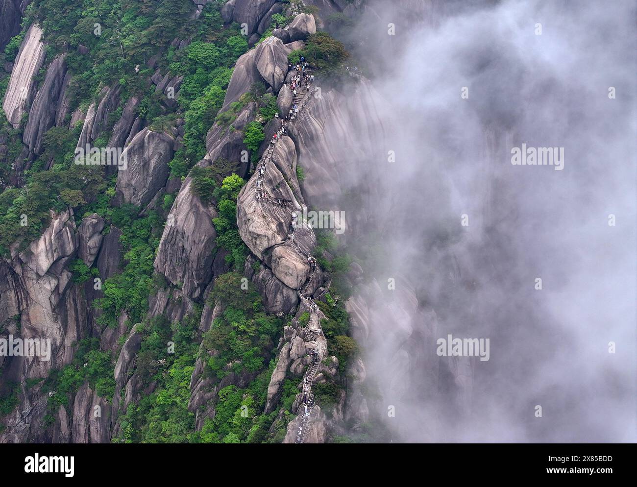(240523) -- HUANGSHAN, 23. Mai 2024 (Xinhua) -- ein Luftdrohnenfoto vom 20. Mai 2024 zeigt Touristen, die den Tiandu-Gipfel im Huangshan-Gebirge in Huangshan-Stadt, ostchinesischer Provinz Anhui besuchen. Der Tiandu-Gipfel, einer der beliebtesten Sehenswürdigkeiten in der malerischen Gegend des Huangshan Mountain, wurde kürzlich nach einer Rotationsschließung wieder eröffnet, die der Natur Ruhe und Selbstreparatur ermöglicht. (Foto: Shi Yalei/Xinhua) Stockfoto
