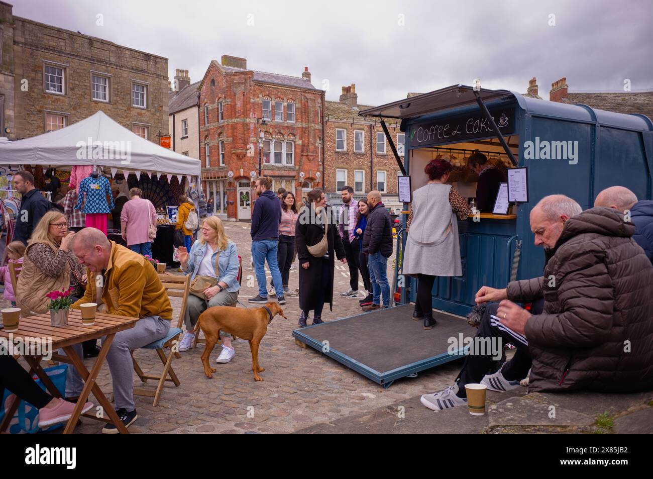 Mobile Kaffeestation und Gäste auf dem Hauptplatz von Richmond in Yorkshire an einem geschäftigen Wochenende Stockfoto