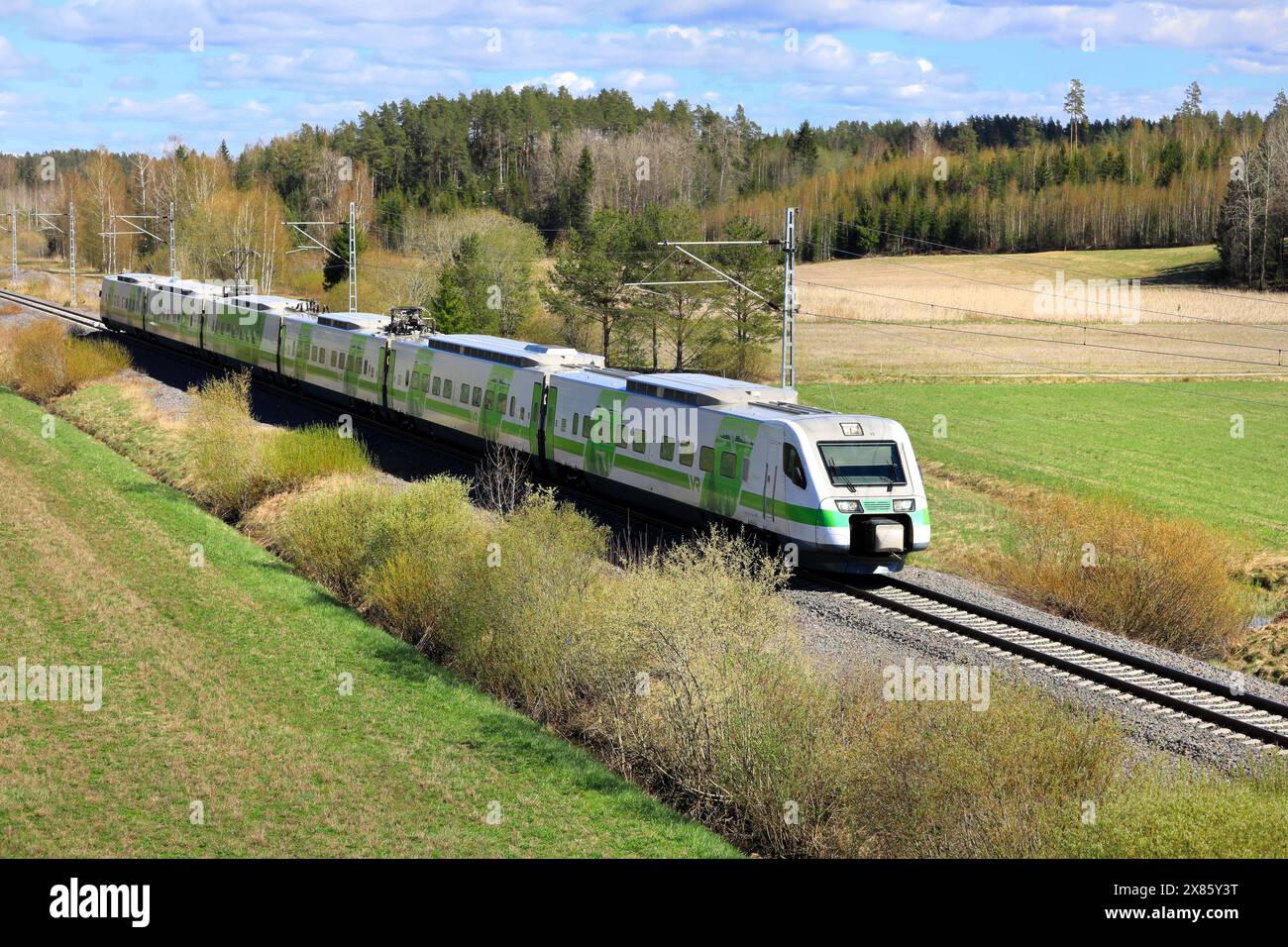 Pendolino Express-Zug der VR-Gruppe von Helsinki nach Kupittaa, Finnland, der im Frühjahr durch ländliche Landschaften fährt. Salo, Finnland. Mai 2024 Stockfoto