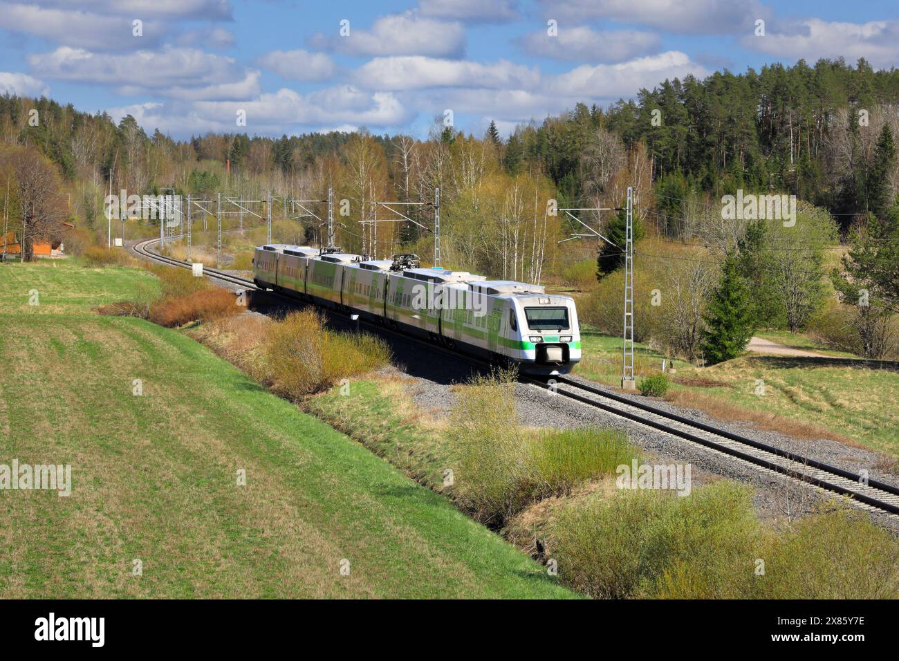Finnische VR Group Pendolino Express Zug von Helsinki nach Kupittaa, der an einem Frühlingstag durch die ländliche Landschaft fährt. Salo, Finnland. Mai 2024. Stockfoto
