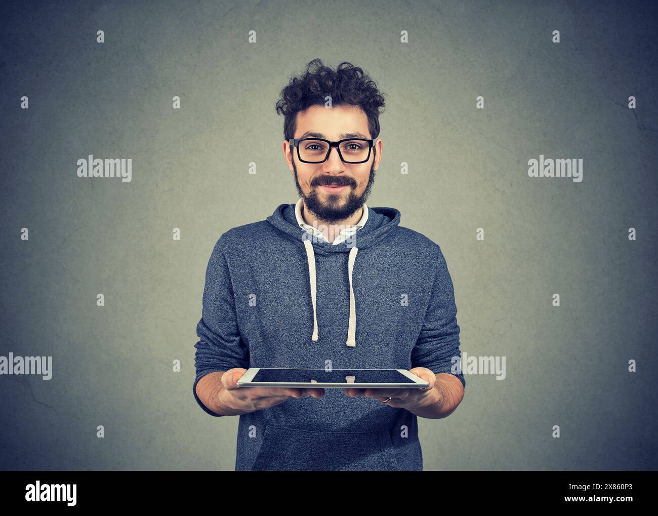 Hübscher Hipster-Typ mit einem Pad-Computer, der in die Kamera schaut Stockfoto